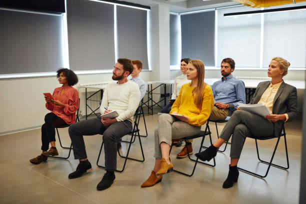Group Of People Listening Presentation In Conference Room.